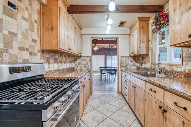 kitchen with sink, stainless steel range with gas cooktop, light brown cabinetry, and beamed ceiling