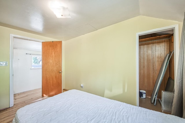 bedroom featuring lofted ceiling, a closet, and hardwood / wood-style flooring