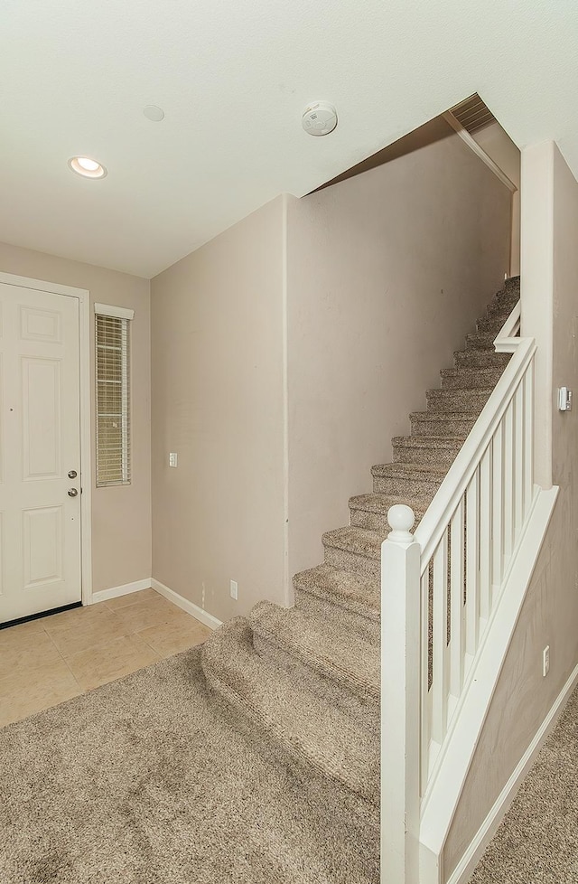 stairway featuring tile patterned flooring, baseboards, and recessed lighting