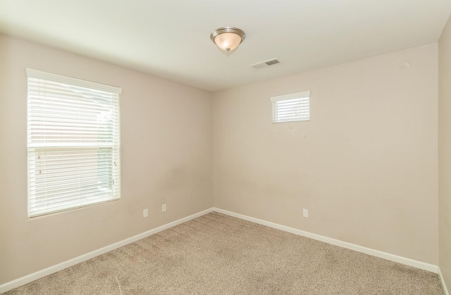 carpeted spare room with baseboards and visible vents