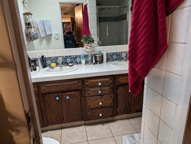 bathroom with tile patterned flooring, vanity, and decorative backsplash