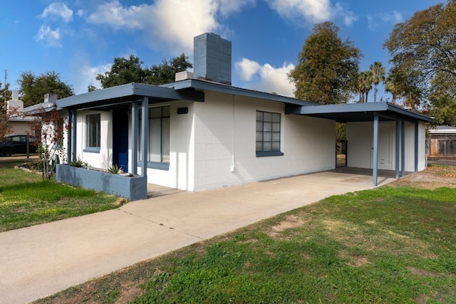 view of side of property with a yard and a carport