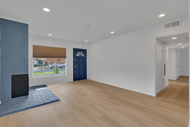 foyer featuring a large fireplace and light hardwood / wood-style flooring