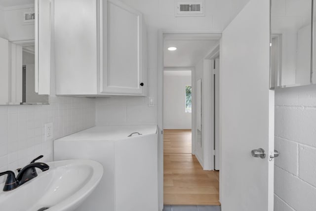 bathroom with tasteful backsplash and sink