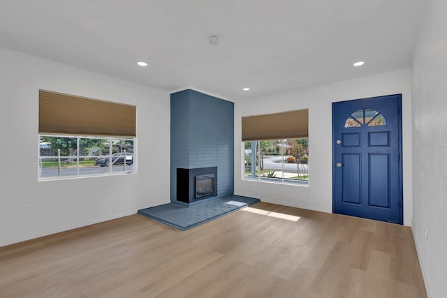 unfurnished living room with light wood-type flooring and a fireplace