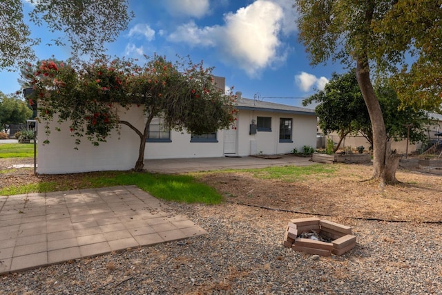 back of property with a patio area and a fire pit