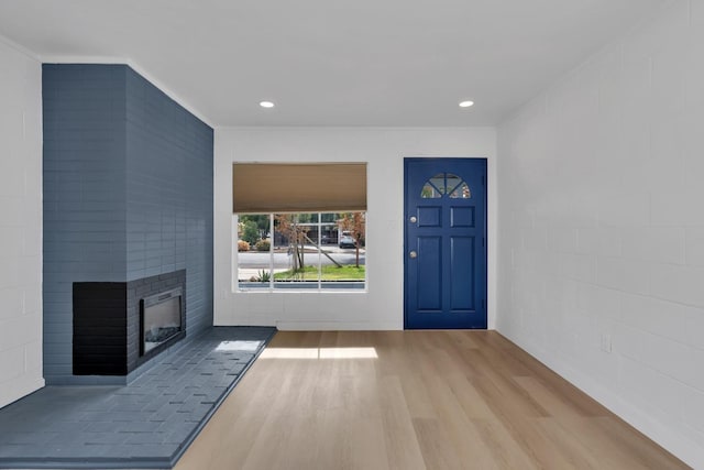 unfurnished living room with a brick fireplace and hardwood / wood-style floors