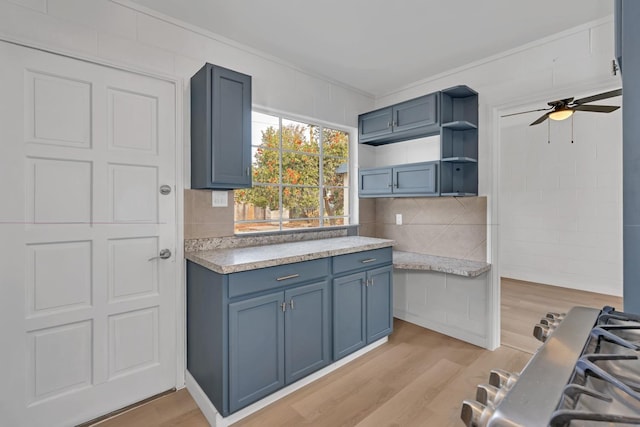 kitchen featuring ceiling fan, light wood-type flooring, decorative backsplash, and ornamental molding