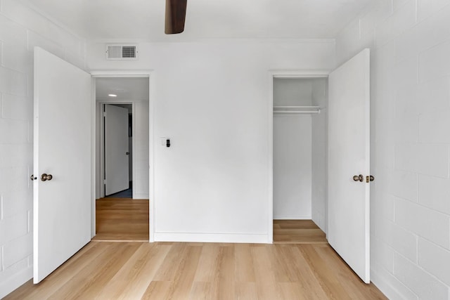 unfurnished bedroom featuring ceiling fan, wood-type flooring, and a closet