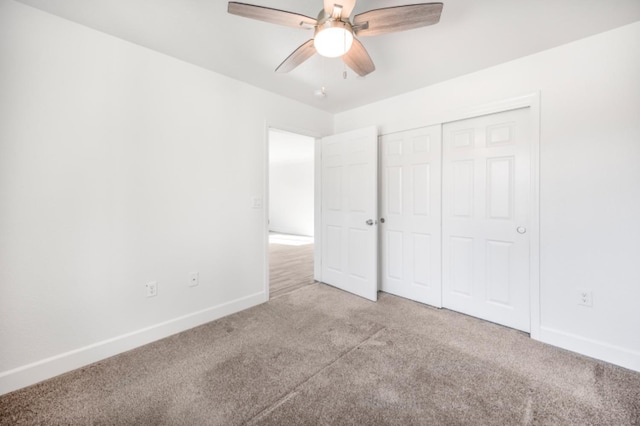 unfurnished bedroom with ceiling fan, light colored carpet, and a closet