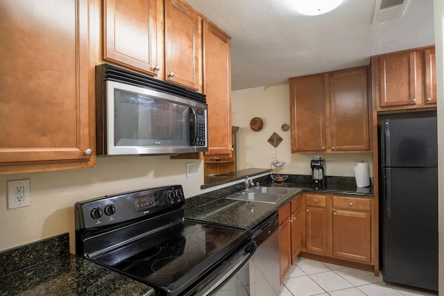 kitchen with dark stone countertops, black appliances, sink, a textured ceiling, and light tile patterned floors