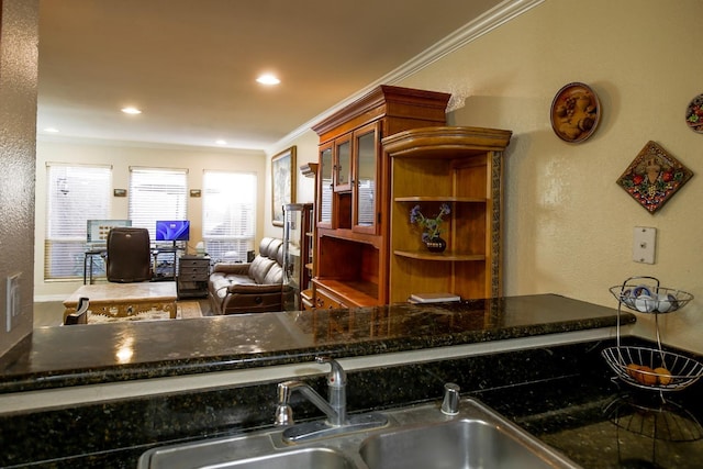 kitchen featuring sink, crown molding, and dark stone countertops