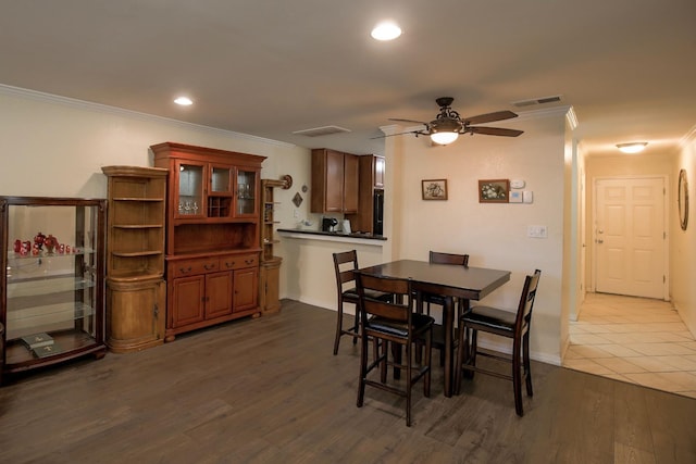 dining space featuring dark wood-type flooring, ornamental molding, and ceiling fan