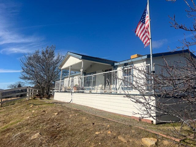 view of home's exterior featuring covered porch and a yard