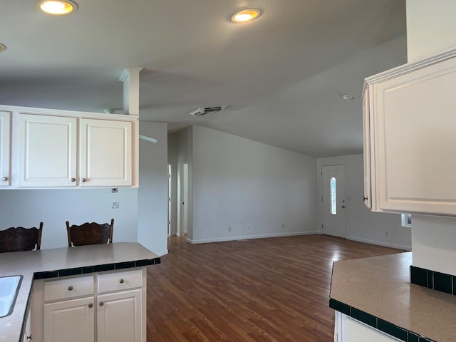 kitchen featuring white cabinetry, visible vents, and dark wood-style flooring