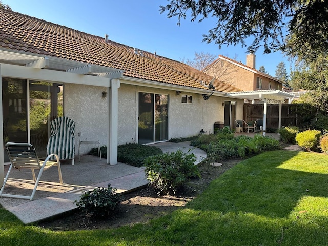 back of house featuring a pergola, a patio area, and a yard