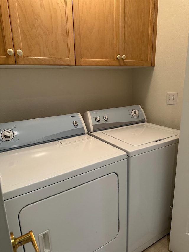 clothes washing area featuring cabinets and independent washer and dryer