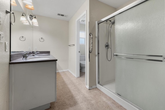 bathroom with toilet, walk in shower, and vanity