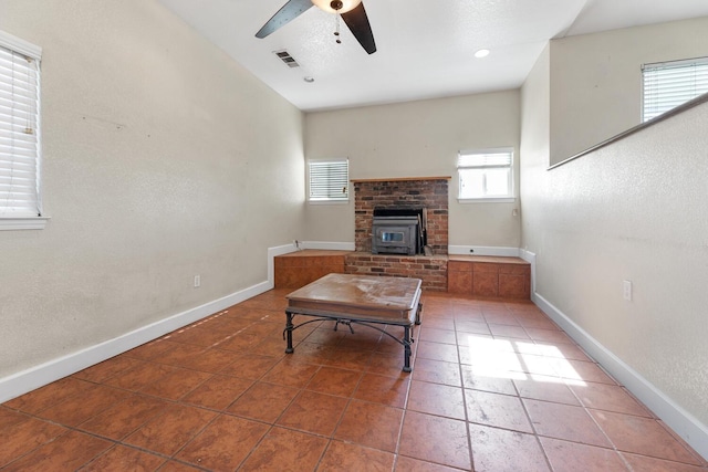 tiled living room featuring ceiling fan and a wood stove