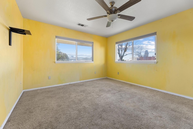 unfurnished room with ceiling fan, carpet flooring, and a healthy amount of sunlight