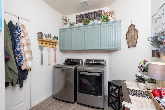 laundry room with cabinets, light tile patterned floors, and independent washer and dryer