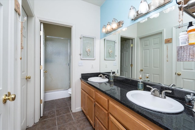 bathroom with toilet, vanity, tile patterned floors, and a shower with door