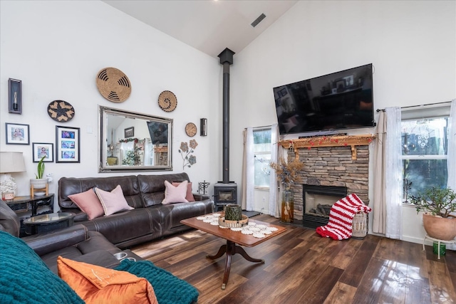 living room with high vaulted ceiling, dark wood-type flooring, and a stone fireplace