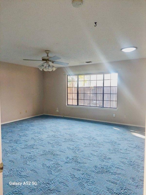 spare room with a textured ceiling, ceiling fan, and carpet flooring