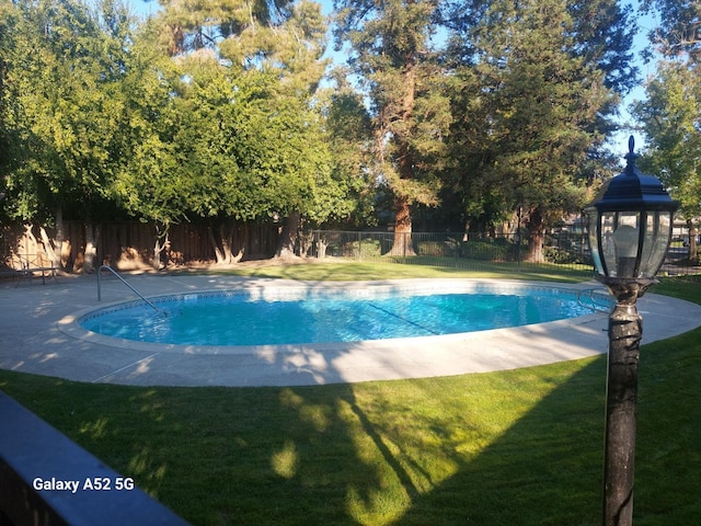 view of swimming pool with a lawn