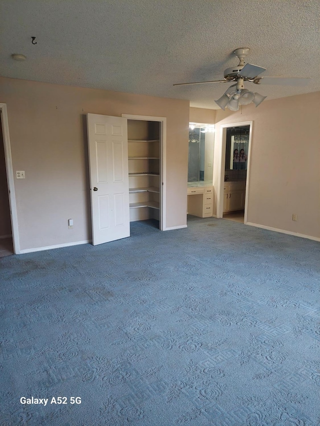 unfurnished bedroom with ceiling fan, a textured ceiling, a closet, and ensuite bath