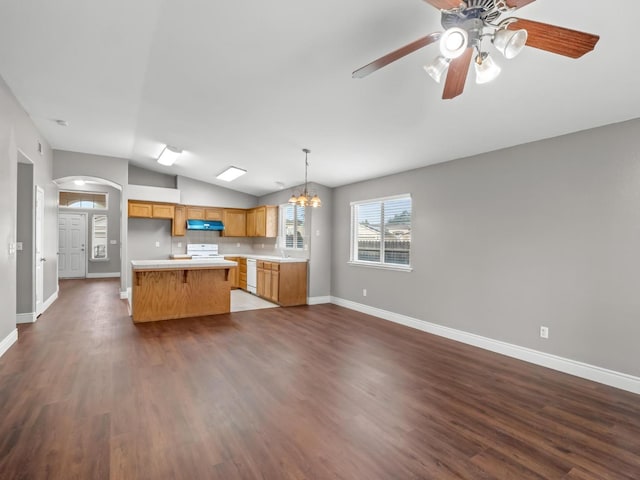 kitchen featuring hanging light fixtures, dark hardwood / wood-style flooring, a center island, vaulted ceiling, and white appliances