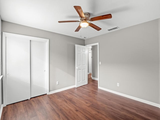 unfurnished bedroom with ceiling fan, a closet, and wood-type flooring