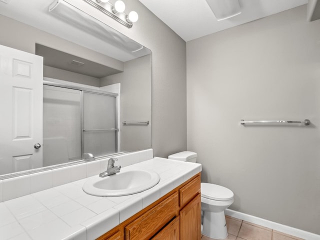 bathroom with vanity, toilet, tile patterned floors, and walk in shower