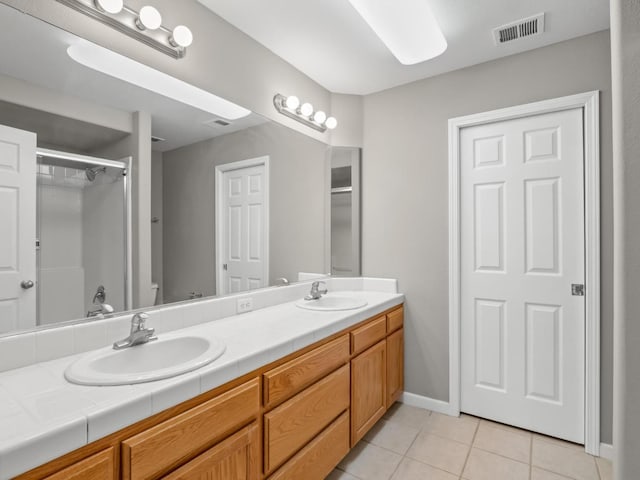 bathroom featuring vanity, tile patterned flooring, and a shower with shower door