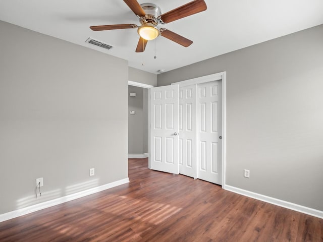 unfurnished bedroom with a closet, dark hardwood / wood-style floors, and ceiling fan