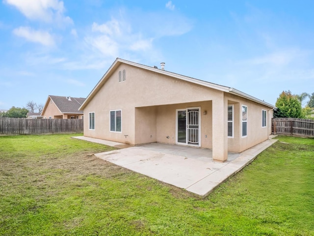 back of house featuring a patio and a yard