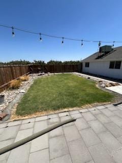 view of yard with central AC and a patio