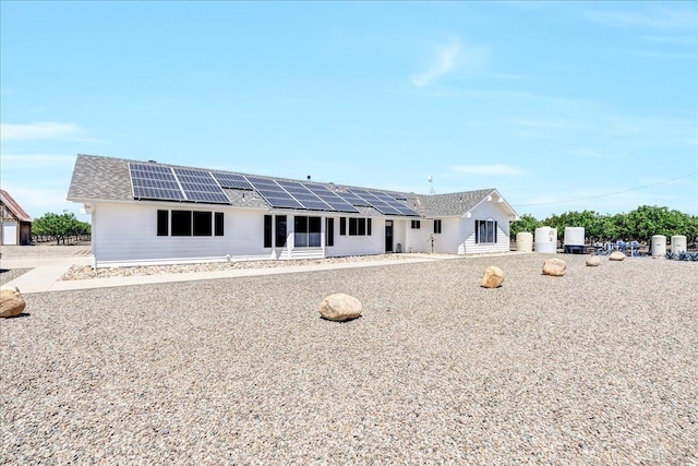 rear view of house featuring solar panels