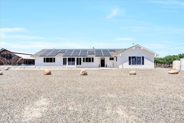 back of house featuring solar panels