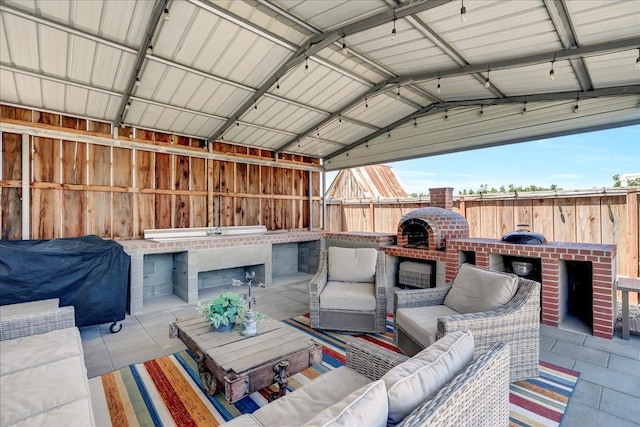 view of patio with an outdoor living space with a fireplace