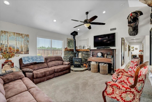 carpeted living room with ceiling fan, a wood stove, and lofted ceiling