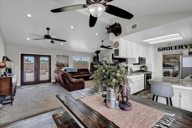 dining area with lofted ceiling, french doors, and hardwood / wood-style flooring