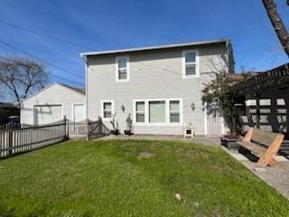 rear view of house featuring fence, a pergola, and a yard