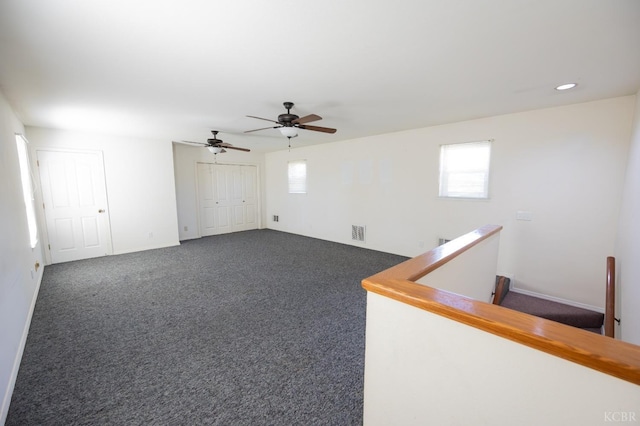 spare room featuring baseboards, dark colored carpet, visible vents, and recessed lighting