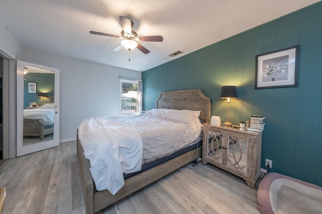 bedroom with a ceiling fan, visible vents, and light wood-style floors