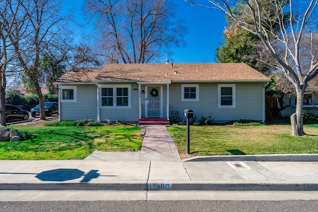 view of front of property with entry steps and a front lawn