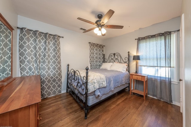 bedroom with a ceiling fan, visible vents, and dark wood-style flooring