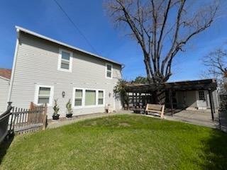 back of house featuring a lawn, fence, and a patio