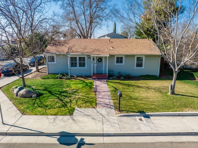 single story home featuring a front lawn and roof with shingles