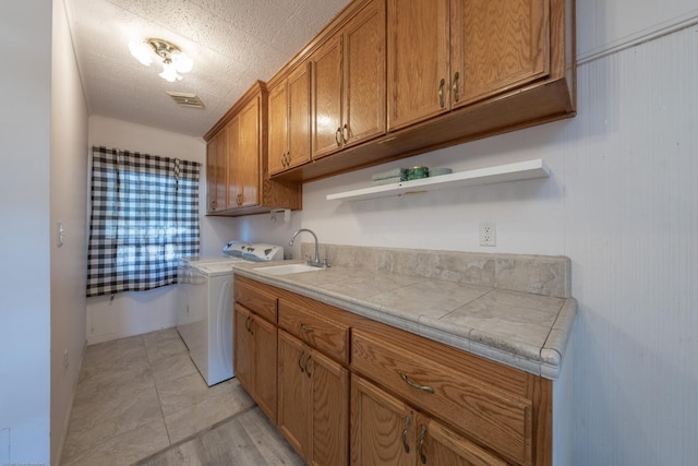 kitchen with visible vents, brown cabinetry, independent washer and dryer, open shelves, and a sink